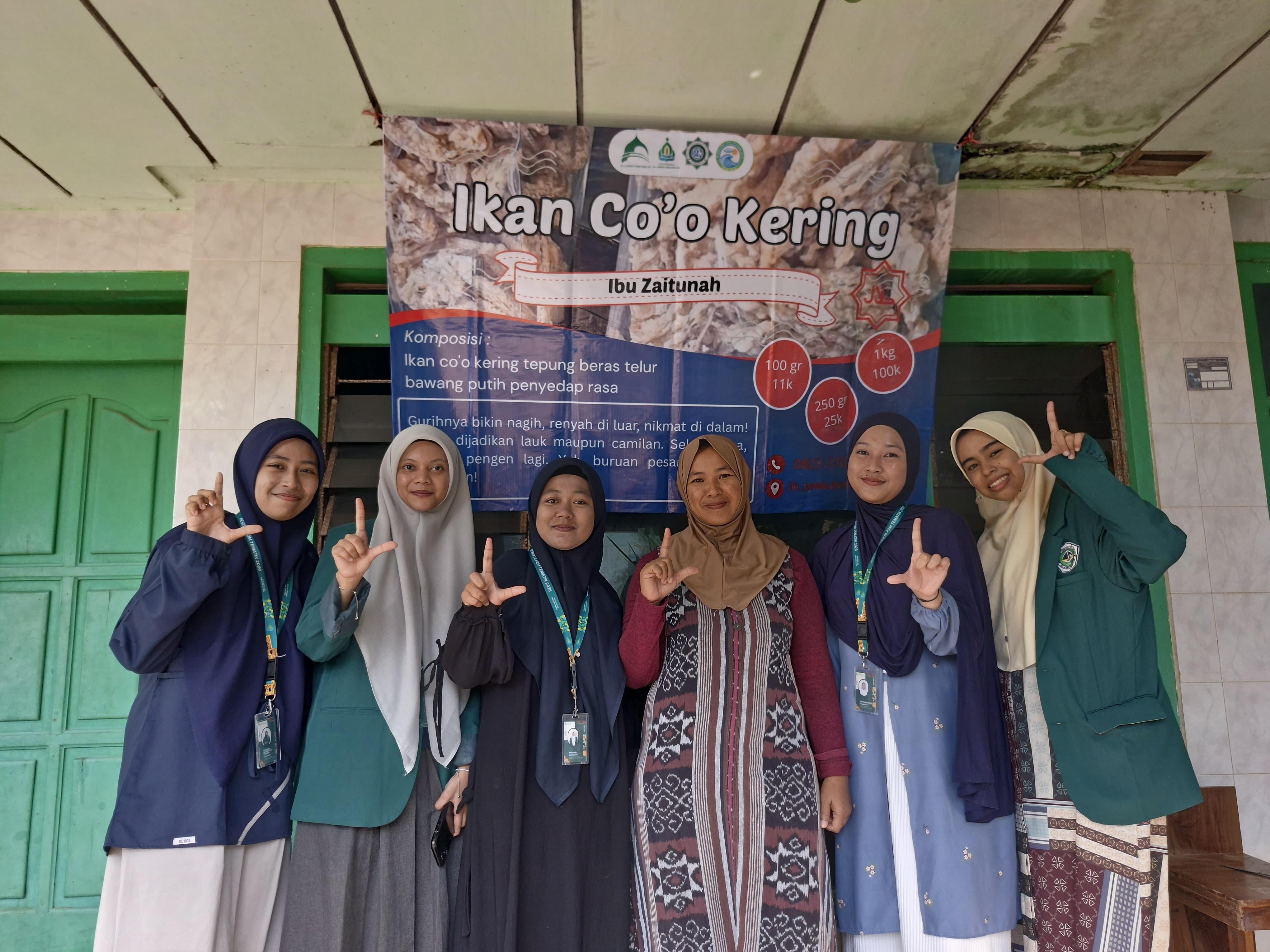 Perkuat Promosi UMKM, Mahasiswi P2M UNIA Pasang Banner Ikan Co'o Krispi 