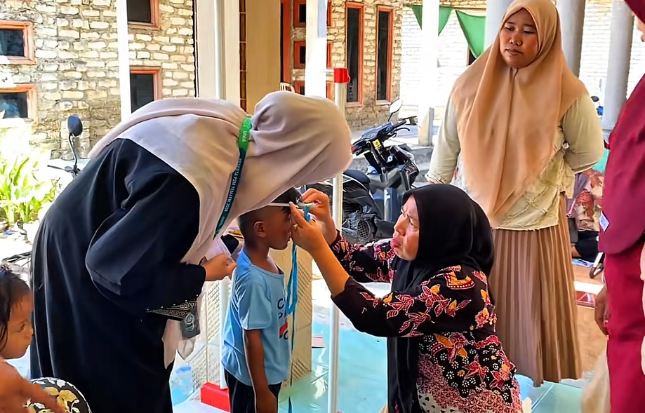 Membantu ibu kader posyandu 